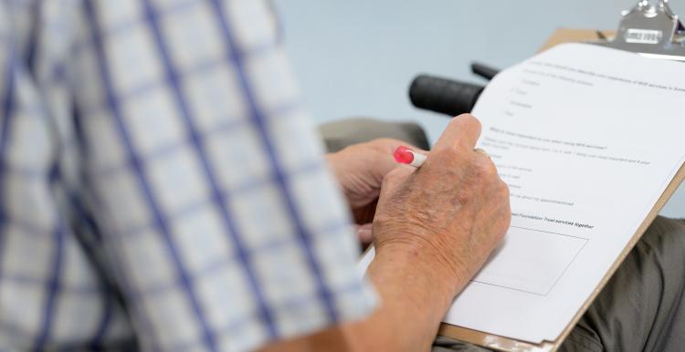 Man's hand completing a survey