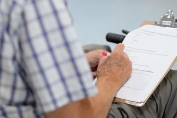 Man's hand completing a survey